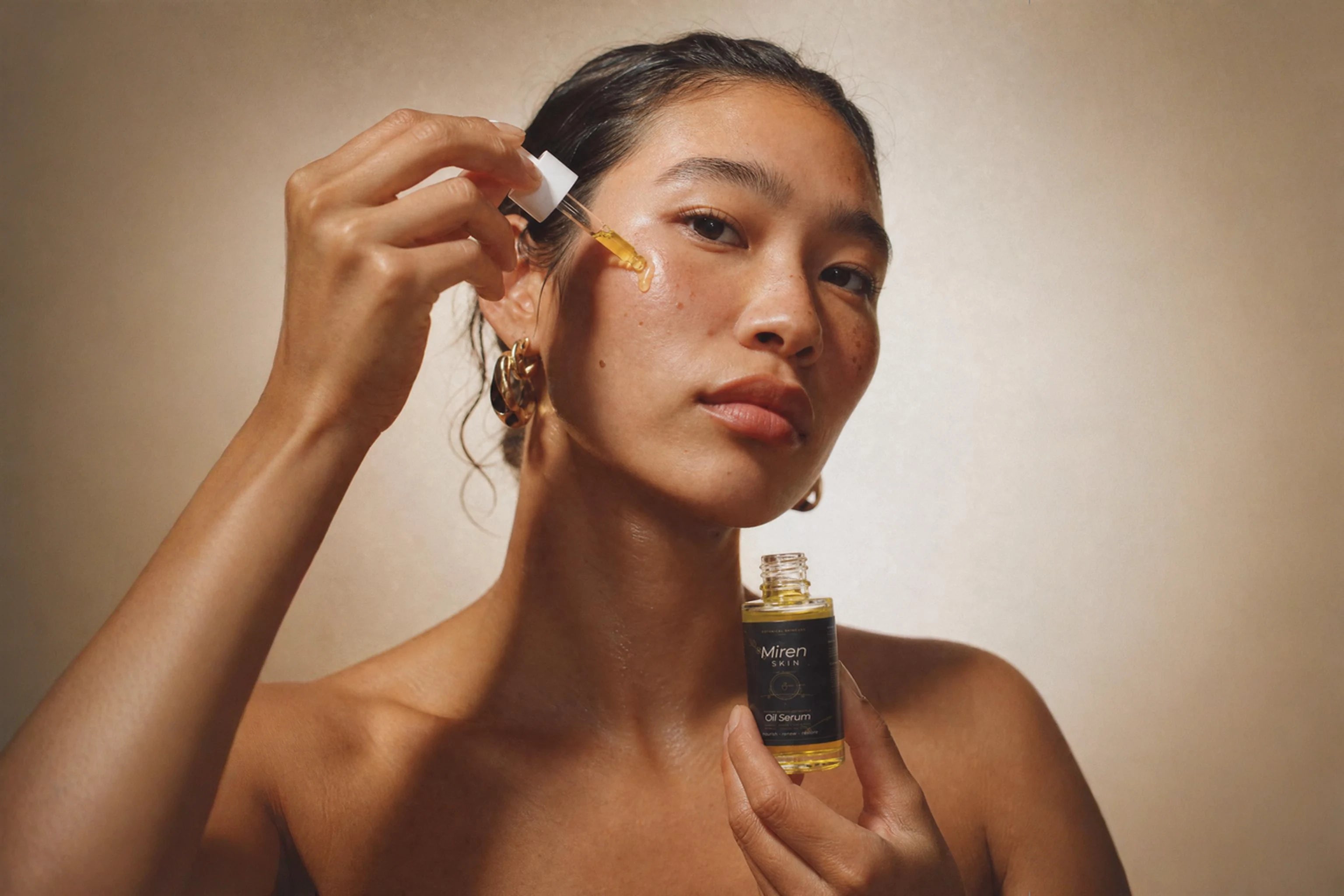 Woman applying a bakuchiol retinol alternative oil serum to her face