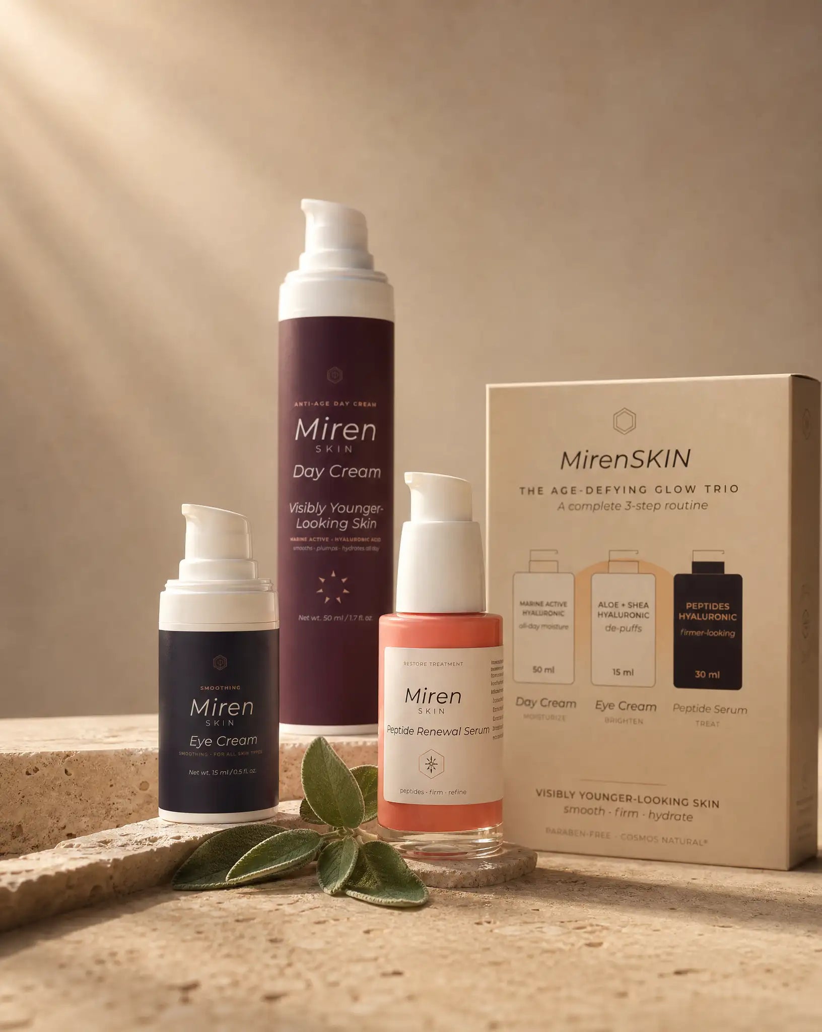 MirenSkin Age-Defying Glow Trio — day cream, eye cream, and peptide serum on travertine